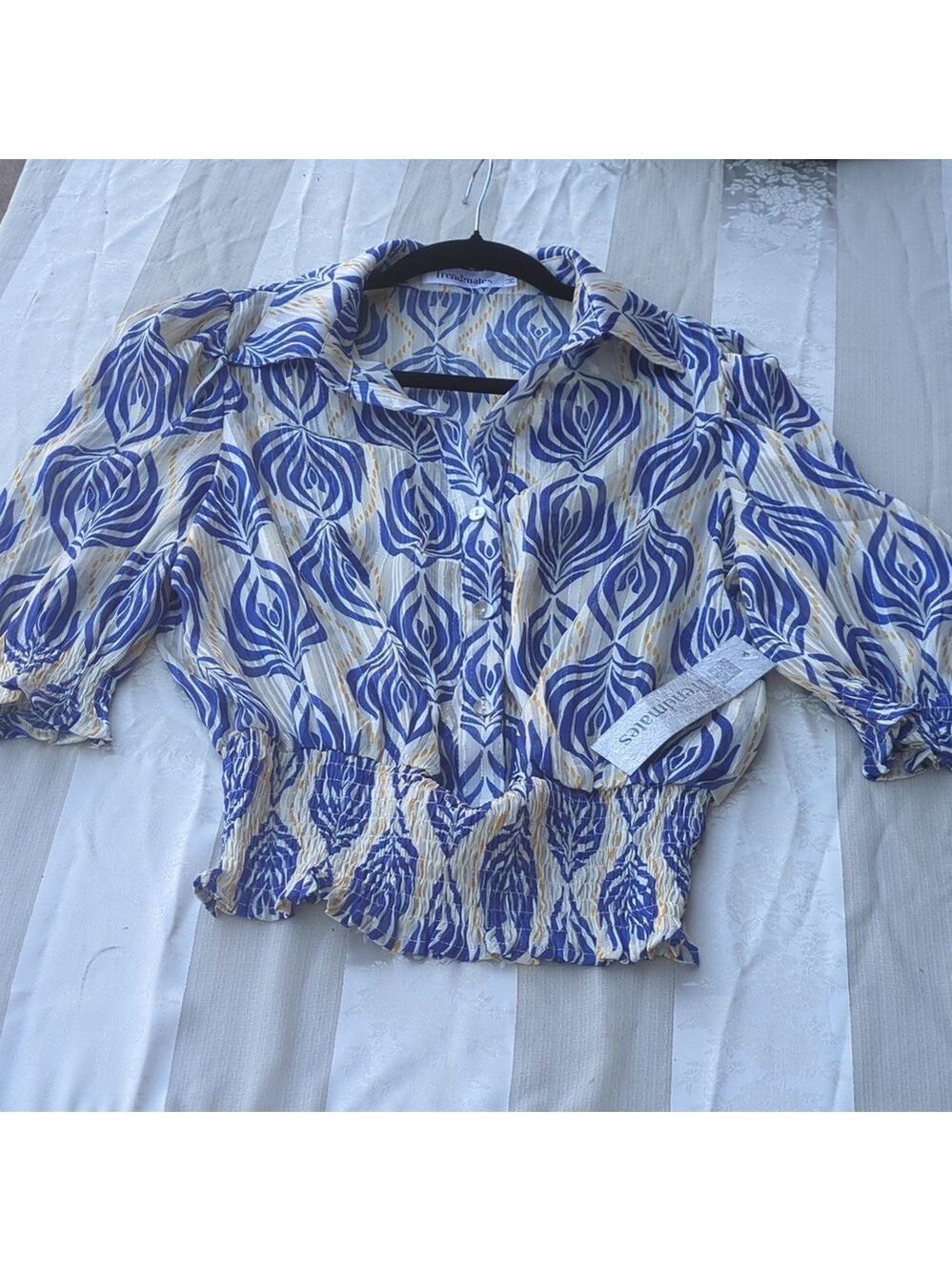 woman's short-sleeve collared top with a shirred, elasticized waist. Medium Size